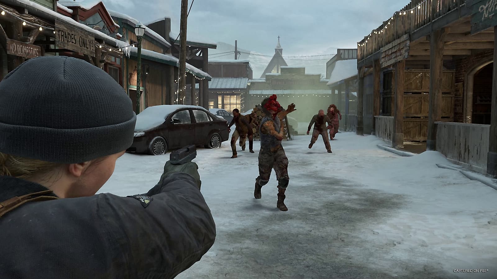 Abby aponta uma pistola para infectados que avançam por uma rua nevada em No Return.