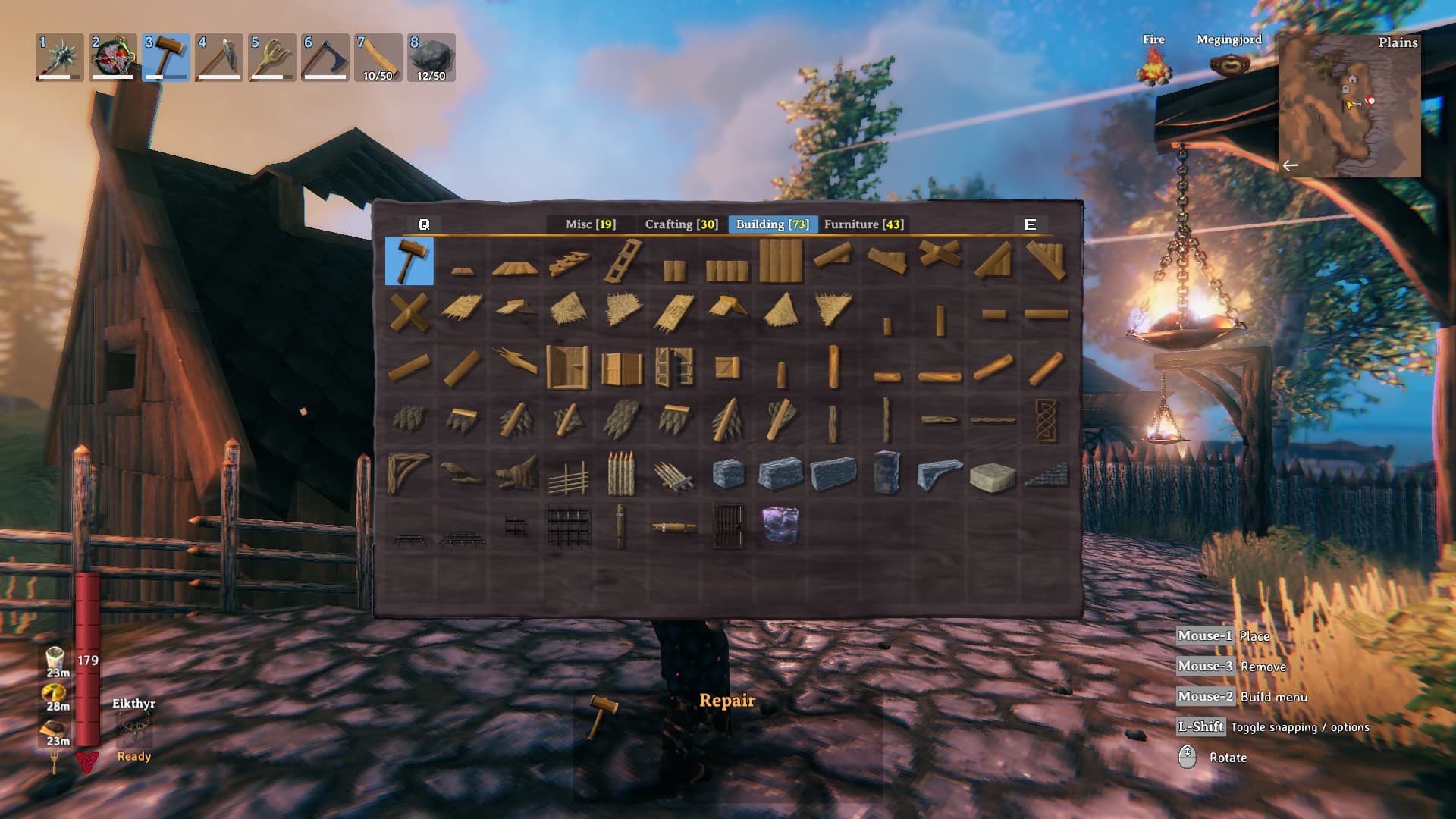 Valheims Baumenü zeigt Holz- und Steinbauteile über einer ausgebauten Siedlung; Hammer und Spiel-HUD sind sichtbar.