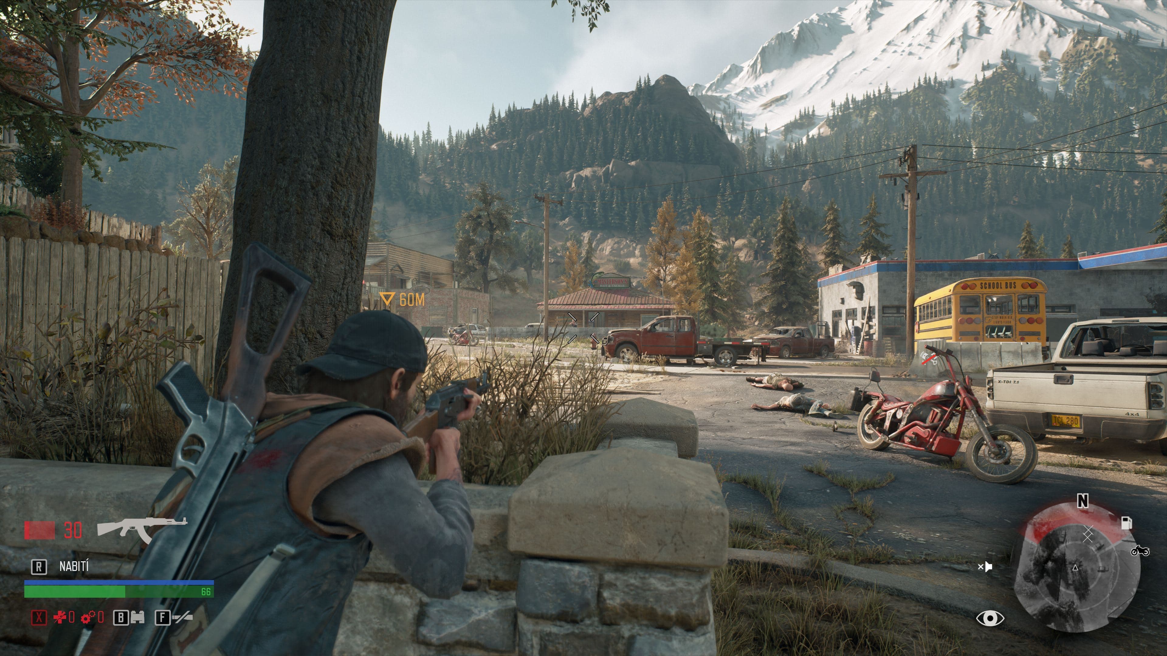 Deacon zielt in Days Gone über eine niedrige Steinmauer mit einem Gewehr auf eine Tankstelle; Munitionsanzeige und Minikarte sind sichtbar.